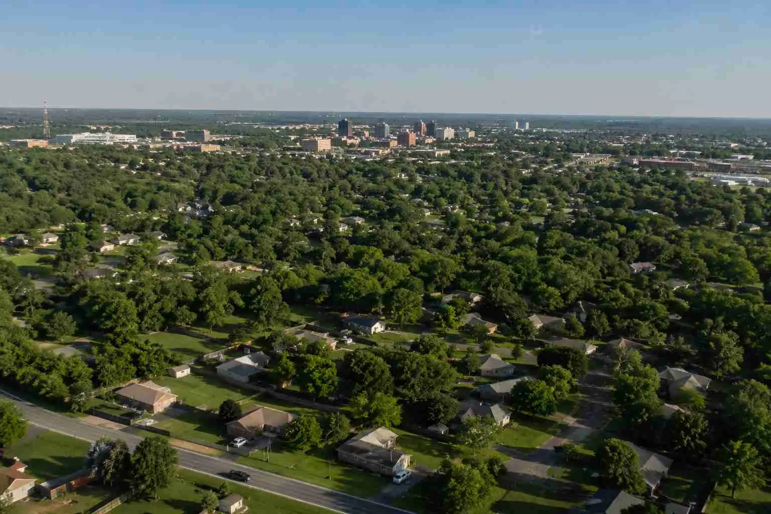 A realistic aerial view of residential neighborhoods and lush green landscapes in East Texas, showcasing affordable homes and growing real estate opportunities in Tyler and surrounding communities.