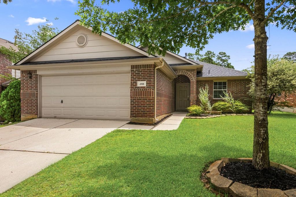 4908 Summer Rain Dr, Conroe, TX 77303 Front view of a single-story brick home with a two-car garage