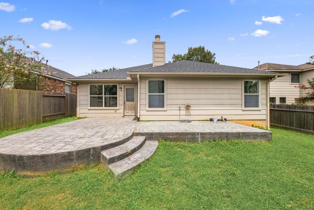 4908 Summer Rain Dr, Conroe, TX 77303 Backyard view of a home with a stamped concrete patio