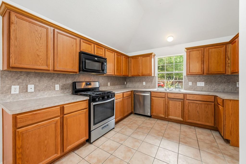 4908 Summer Rain Dr, Conroe, TX 77303 Kitchen interior with wood cabinets and stainless steel appliances